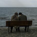 Girl and boy sitting on a beach area