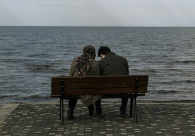Girl and boy sitting on a beach area