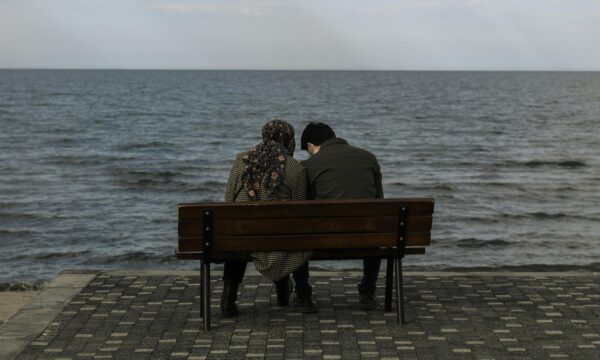 Girl and boy sitting on a beach area
