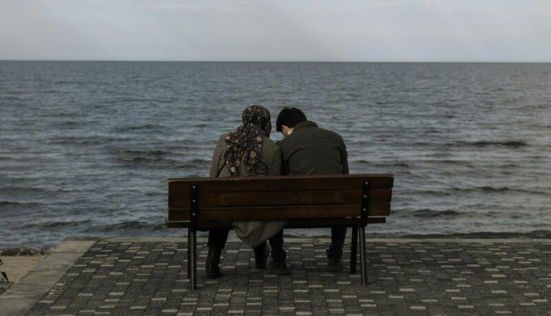 Girl and boy sitting on a beach area